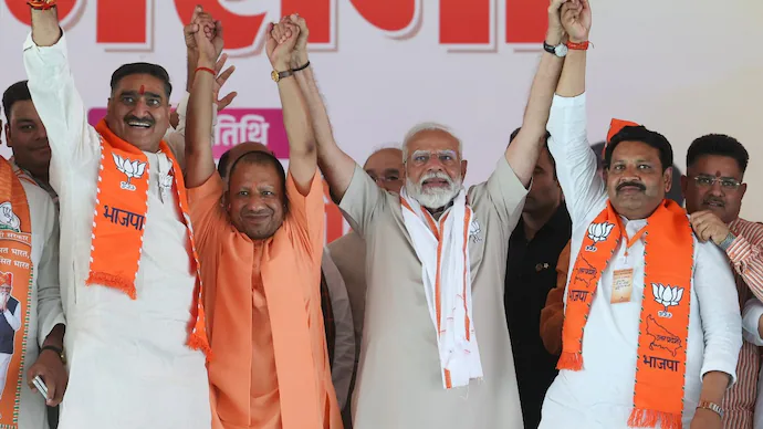अलीगढ़ की चुनावी रैली में जनता का अभिवादन स्वीकार करते प्रधानमंत्री मोदी